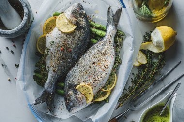 Limonlu ve kuşkonmazlı iki dorado balığı. İki kişilik lezzetli ve sağlıklı bir akşam yemeği konsepti.