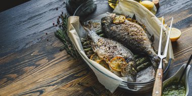 Limonlu ve kuşkonmazlı iki dorado balığı. İki kişilik lezzetli ve sağlıklı bir akşam yemeği konsepti.