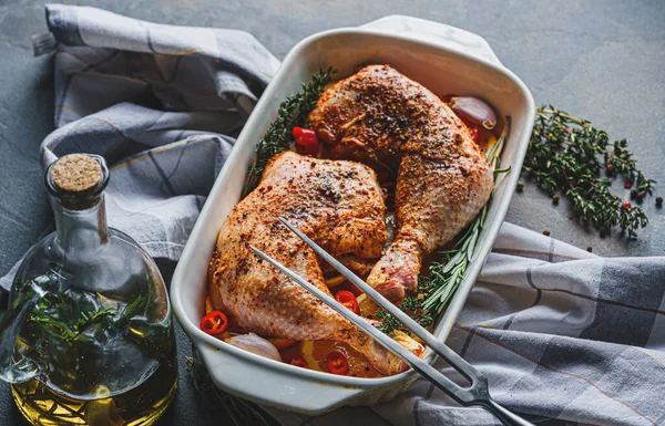 Çiğ hindi butları baharat ve tuzla ovulmuş, fırın tepsisine portakal limonlu sarımsaklı biberiye kekiği ve zeytinyağıyla birlikte. İki kişilik sağlıklı ve lezzetli bir akşam yemeği konsepti.