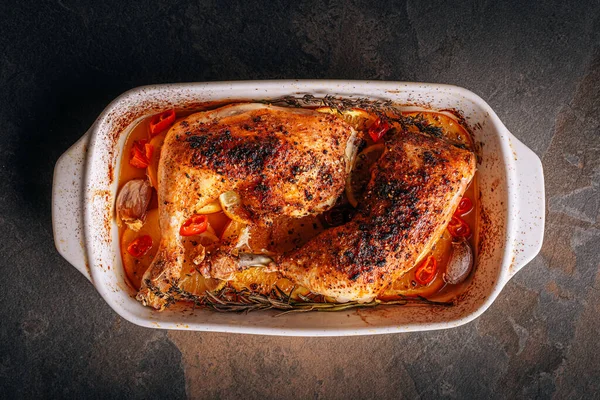 Kızarmış hindi budu, baharat ve tuzla ovulmuş, portakallar, limonlar, sarımsak, biberiye, kekik ve zeytinyağı ile pişirilmiş. İki kişilik sağlıklı ve lezzetli bir akşam yemeği konsepti.