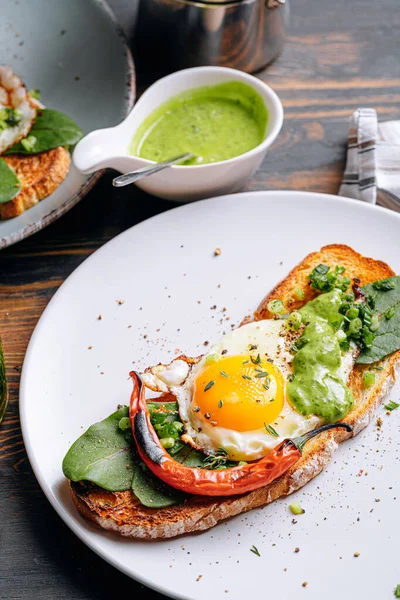 Lezzetli ve iştah açıcı bruschetta ve kahvaltıda kızarmış yumurta ve otlar.