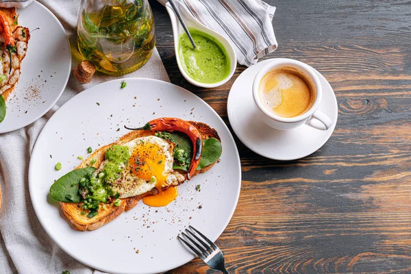 Sıcak ve yüksek kalorili kahvaltı. Lezzetli ve ağız sulandırıcı bruschetta ve kahvaltıda kızarmış yumurta ve bir fincan aromatik kahve..