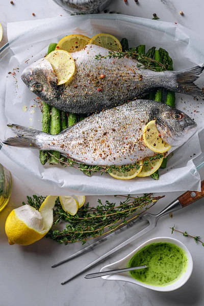 Dorado 'dan iki kişilik lezzetli bir akşam yemeği konsepti. Çiğ Dorado balığı, kuşkonmaz ve baharatlı limon.