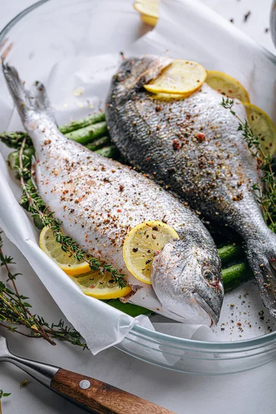 Dorado 'dan iki kişilik lezzetli bir akşam yemeği konsepti. Çiğ Dorado balığı, kuşkonmaz ve baharatlı limon.