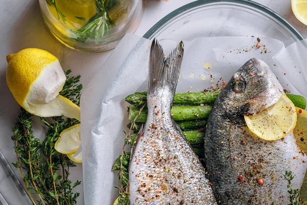 Dorado 'dan iki kişilik lezzetli bir akşam yemeği konsepti. Çiğ Dorado balığı, kuşkonmaz ve baharatlı limon.