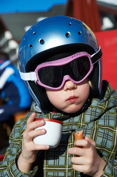 Bambina in casco da sci e bicchieri mangia e beve — Foto Stock