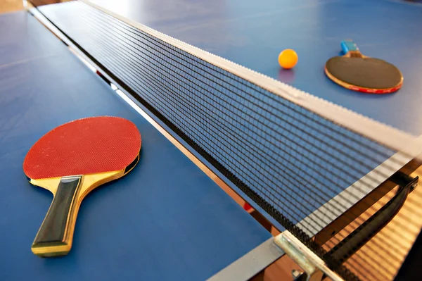 Raquetas de tenis de mesa y pelota naranja — Foto de Stock