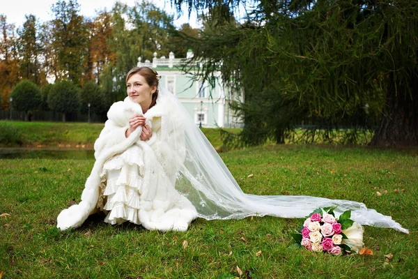 Sposa in abito bianco e mazzo di fiori — Foto Stock