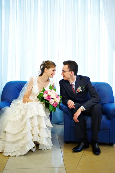 Bride and groom in a blue armchair — Stock Photo, Image