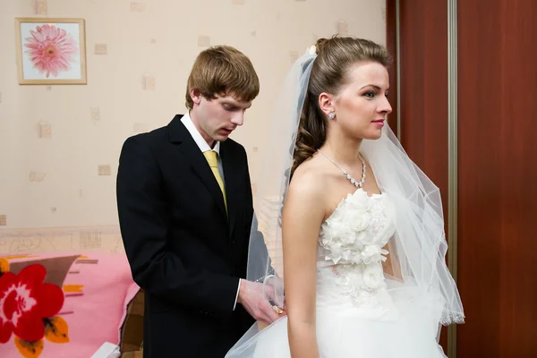 Groom ties a corset — Stock Photo, Image