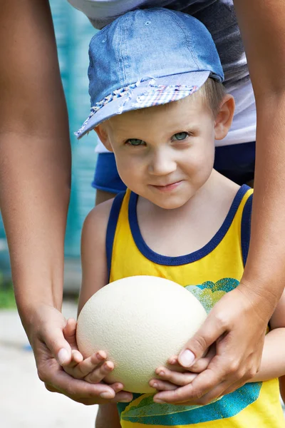 Küçük çocuk bir devekuşu eggj holding — Stok fotoğraf