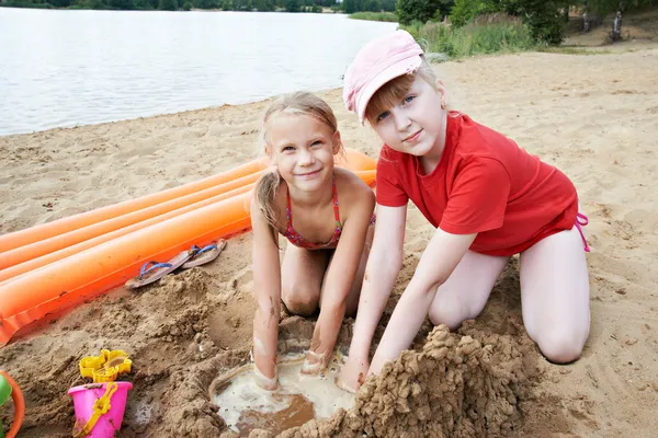 Happy little girls play on sand beach — Stock Photo, Image