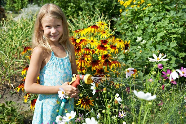 Little girl watering flowers — Stock Photo, Image