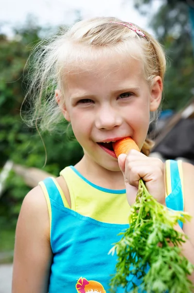 Klein meisje eten wortel — Stockfoto