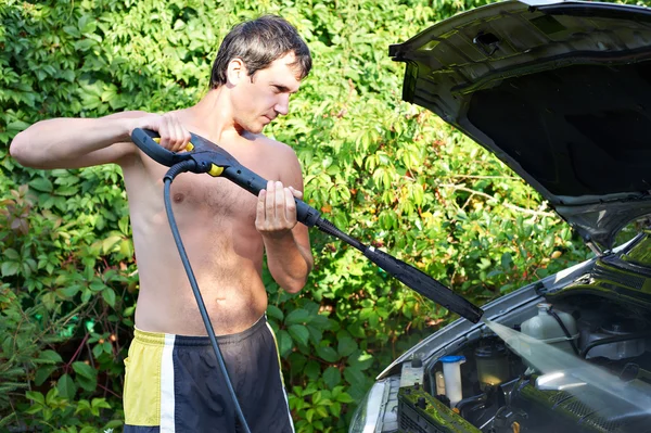 Jeunes hommes nettoyage de voiture avec de l'eau sous pression — Photo