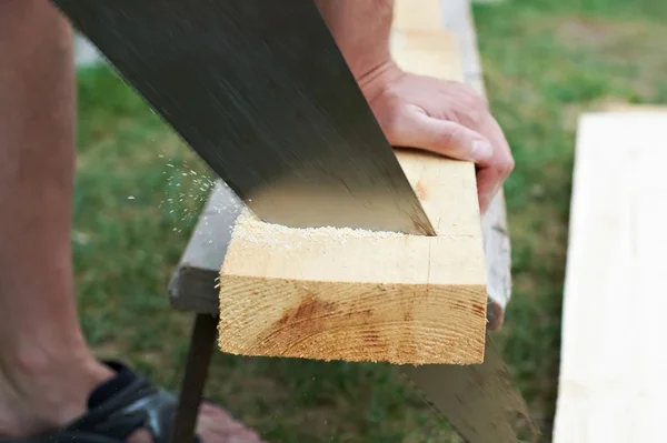 Mann sägt ein Holzbrett — Stockfoto