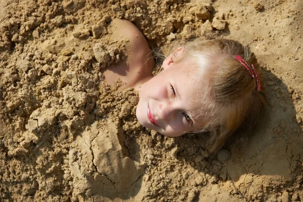 Küçük kız kum üzerinde yalan — Stok fotoğraf
