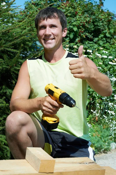 Een man boren een stuk hout — Stockfoto