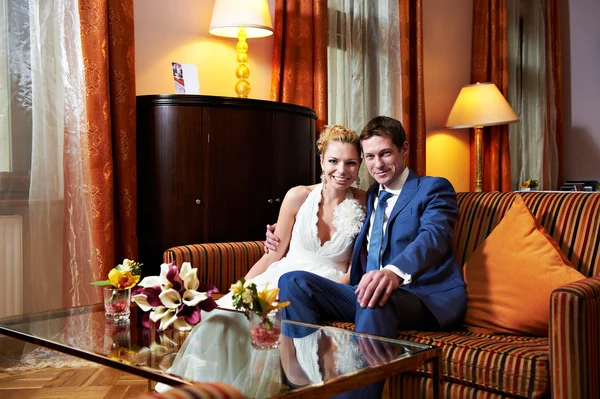 Happy bride and groom in interior of hotel room — Stock Photo, Image