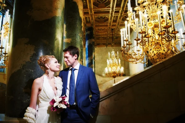 Happy bride and groom in interior of hotel — Stock Photo, Image