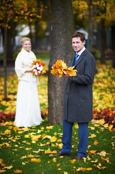 Novia y novio con una hoja de arce — Foto de Stock