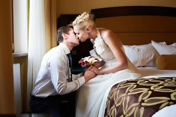 Romantic kiss bride and groom in bedroom — Stock Photo, Image
