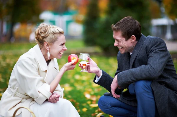 Groom with glass of brandy, and bride with red apple — Stock Photo, Image