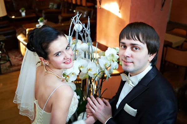 Happy bride and groom near flowers — Stock Photo, Image