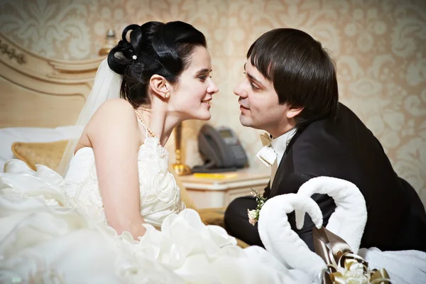 Handsome bride and groom in bedroom — Stock Photo, Image