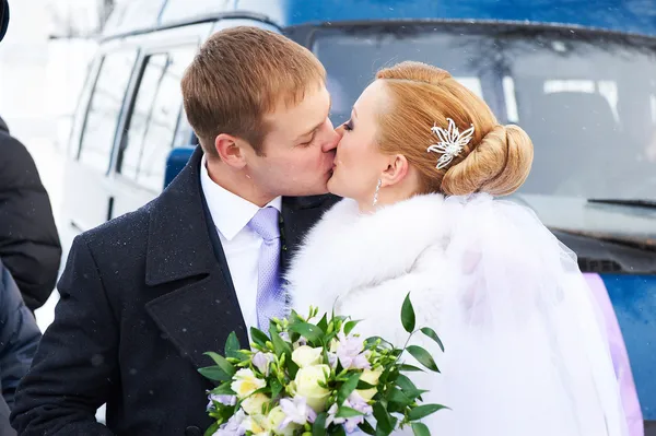 Kiss happy bride and groom on winter day — Stock Photo, Image