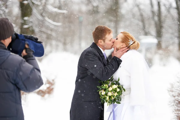 Operator shooting romantic kiss happy bride and groom — Stock Photo, Image