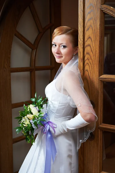 Noiva bonita feliz com buquê perto de portas — Fotografia de Stock
