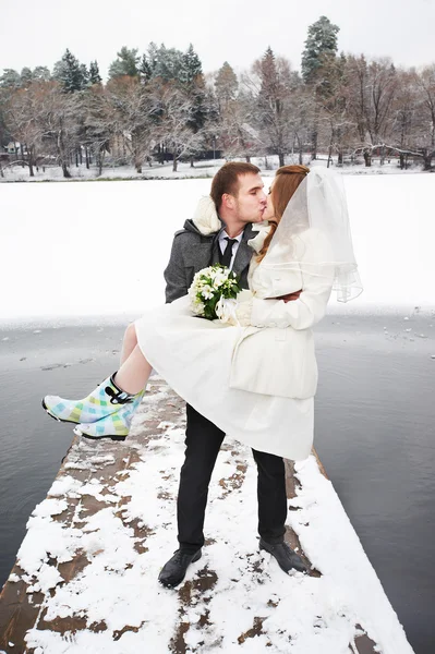 Kiss bride and groom on walk in winter — Stock Photo, Image