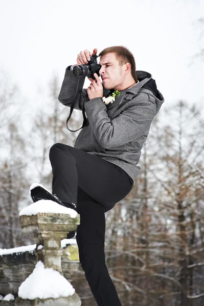Young man with a camera at winter — Stock Photo, Image