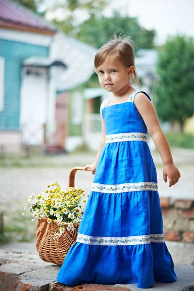 Petite fille avec des fleurs dans le panier — Photo