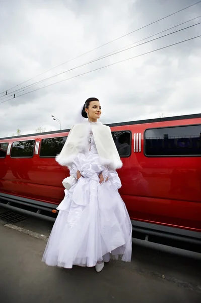 Невеста на заднем плане красный лимузин автомобиль — стоковое фото