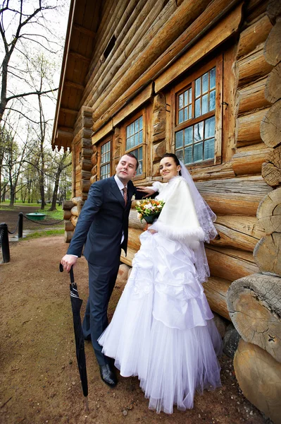 Schönheit Braut und eleganter Bräutigam in der Nähe von altem Holzhaus — Stockfoto