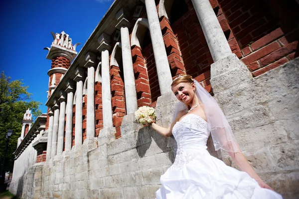 Glückliche Braut an der Mauer zum Palast — Stockfoto