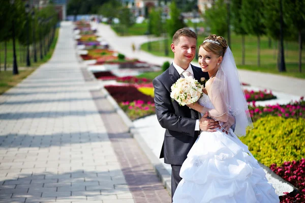 Sposa felice e sposo a passeggiata nuziale in parco — Foto Stock