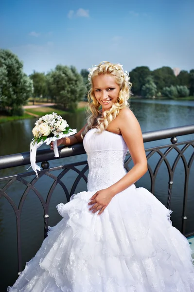 Noiva feliz com buquê de flor perto do lago — Fotografia de Stock