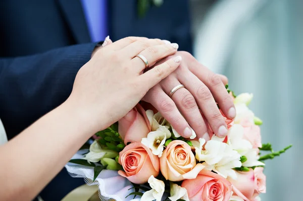 Mãos com anéis de ouro do casamento — Fotografia de Stock