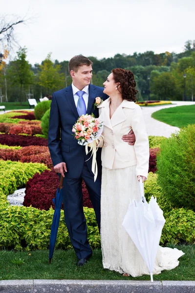 Happy bride and groom at wedding walk in park — Stock Photo, Image