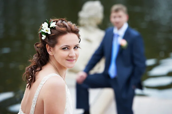 Happy bride and groom near lake — Stock Photo, Image