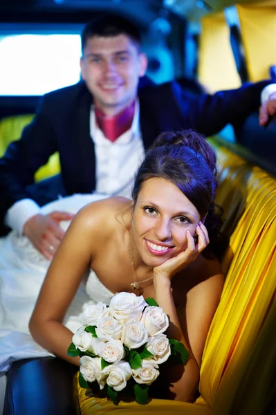 Bride and groom in wedding limousine — Stock Photo, Image
