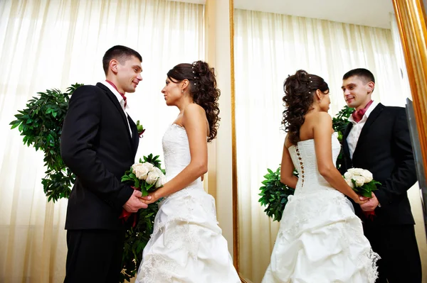 Romantic bride and groom near mirror — Stock Photo, Image