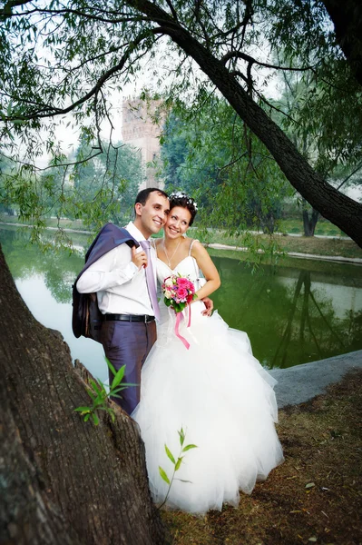 Счастливая невеста и жених на берегу озера — стоковое фото