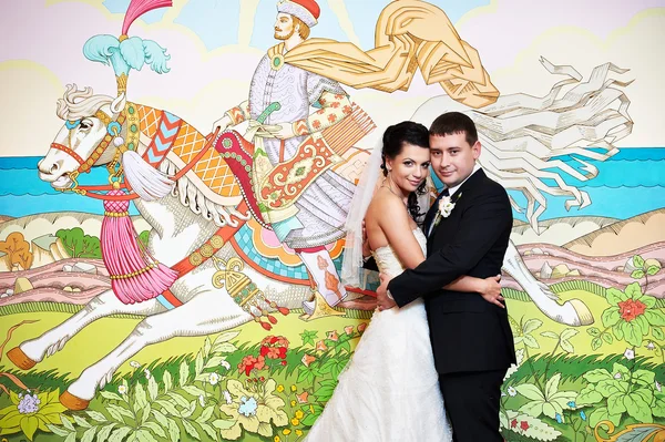 Happy bride and groom on background picture of fairy tales — Stock Photo, Image