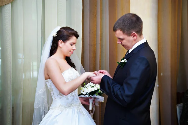 エレガントな新郎幸せな花嫁の結婚指輪を着ています。 ストック写真