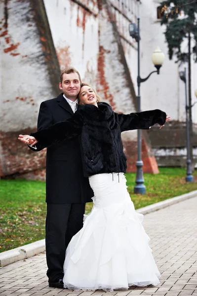 Happy bride and groom near ancient wall — Stock Photo, Image