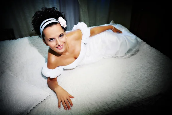 Beautiful bride on white bed — Stock Photo, Image